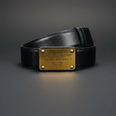 Black Dolce & Gabbana belt with gold plaque on a dark gray background